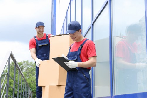 Piano moving team handling an upright piano in Highbury