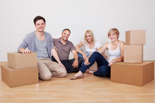 Moving crew carrying furniture through a Highbury apartment building entrance